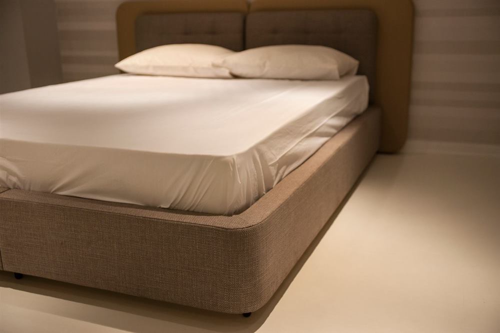 Close-up of a mattress seam and corner in a bedroom - common bed bug hiding spot
